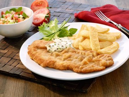 Costeletas de porco panadas com salada e molho de ervas